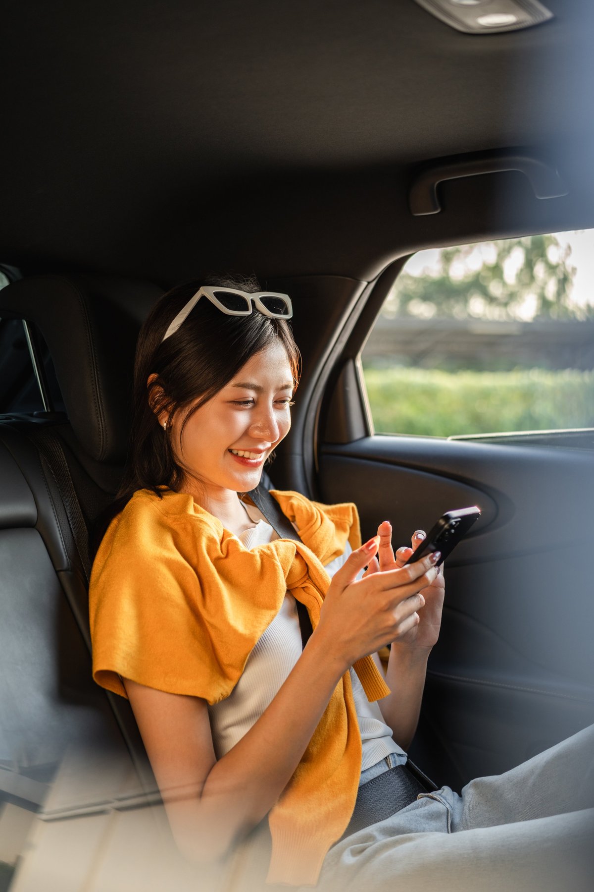 Woman relaxing in the back seat of a private car while traveling